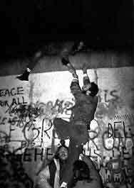 Men climbing the Berlin Wall